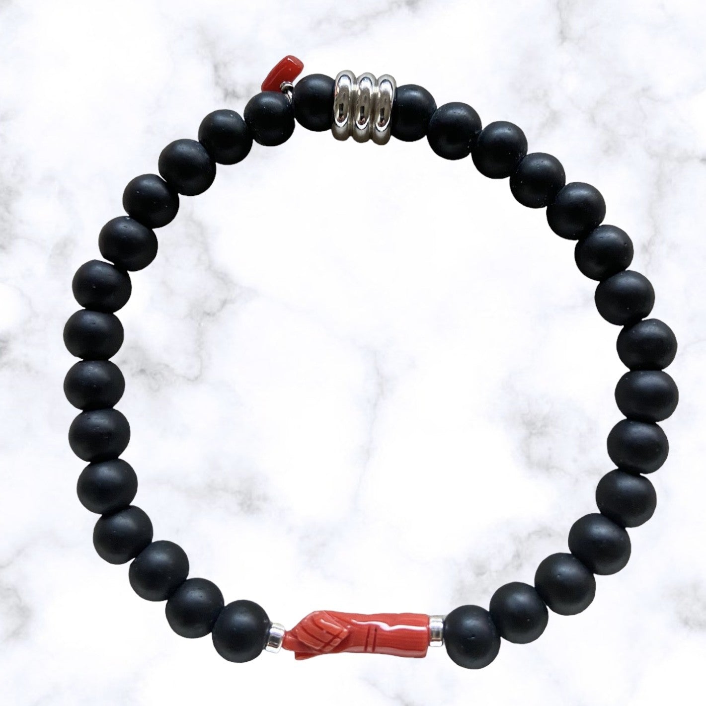 Bracelet élastique en perles d'Onyx noir mat avec "la main de protection" en corail rouge de Méditerranée.L'Onyx renforce l'estime de soi et la confiance en soi.Le Corail protège, porte bonheur et éloigne le mauvais œil