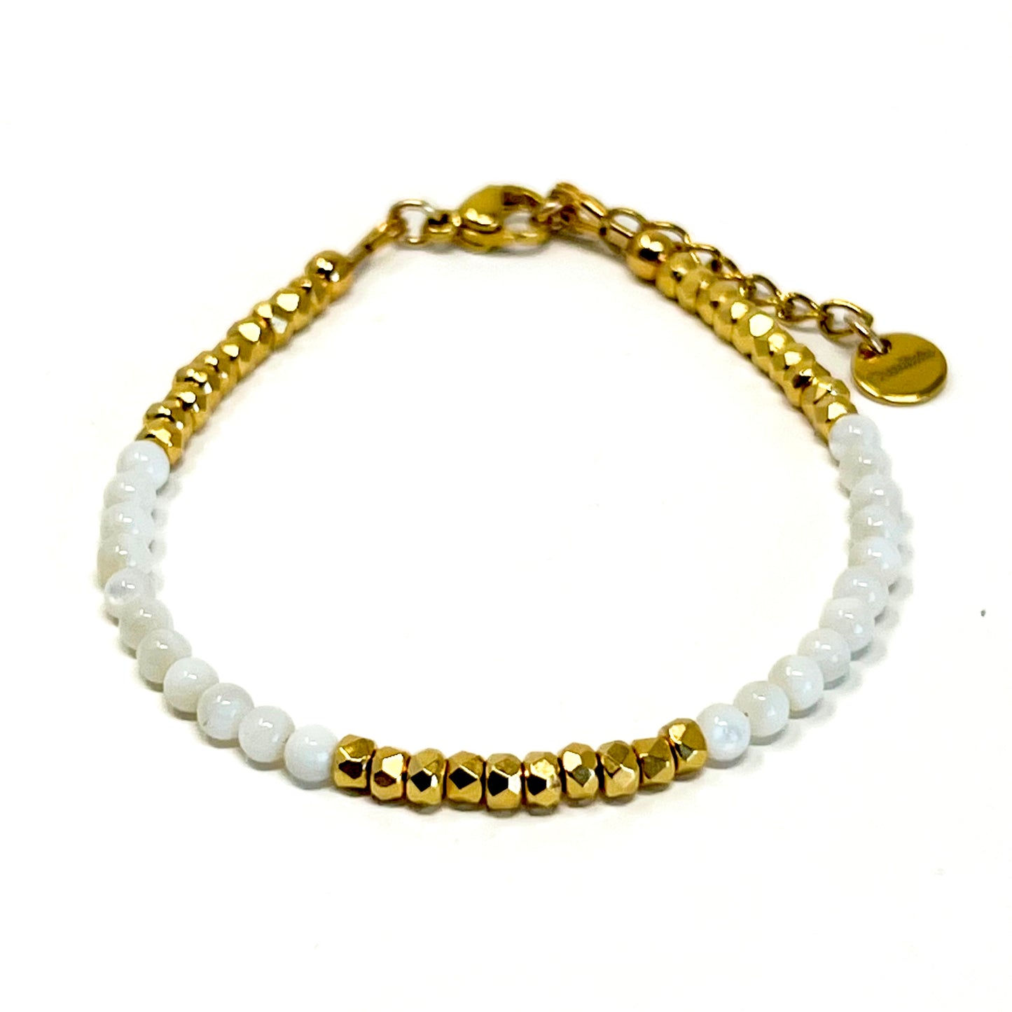 Le Bracelet Naïa associe la délicatesse de la Nacre blanche à la brillance des perles en verre facettées plaquées or 24 carats, offrant un bijou lumineux et élégant.Symbole de calme et d’apaisement, la Nacre apporte douceur et sérénité à celle qui la porte.