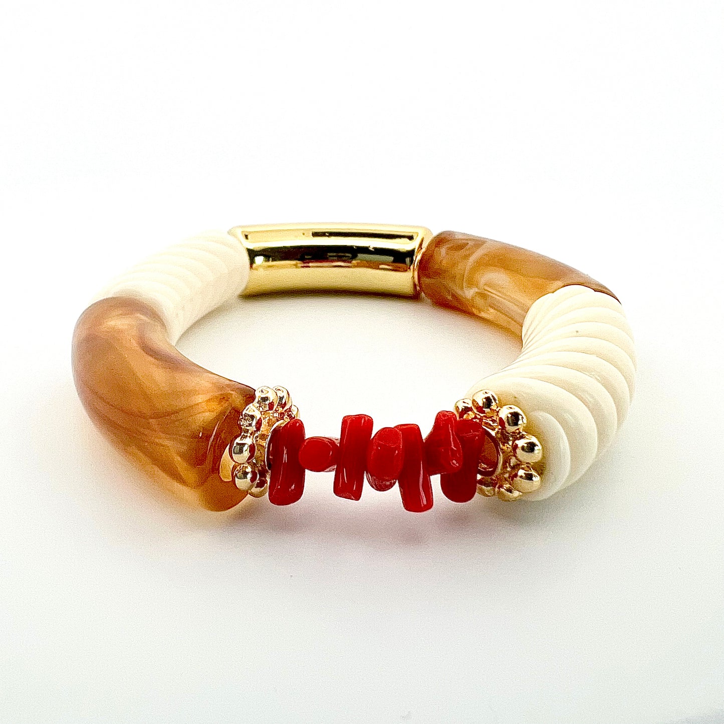 Le bracelet Goa beige torsadé, fait main, associe l’élégance de l’acrylique a finesse des rondelles dorées à l’or fin et la symbolique du Corail rouge de Méditerranée, connu pour ses vertus protectrices et porte-bonheur