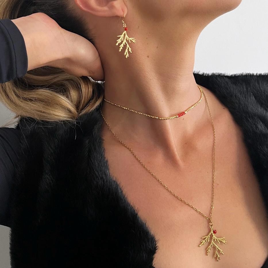 Ce collier élégant en acier inoxydable doré est sublimé par un pendentif en forme de branche de corail, accompagné d’une perle en corail rouge de Méditerranée. À la fois résistant et raffiné, il ajoute une touche naturelle et discrète à toutes vos tenues.