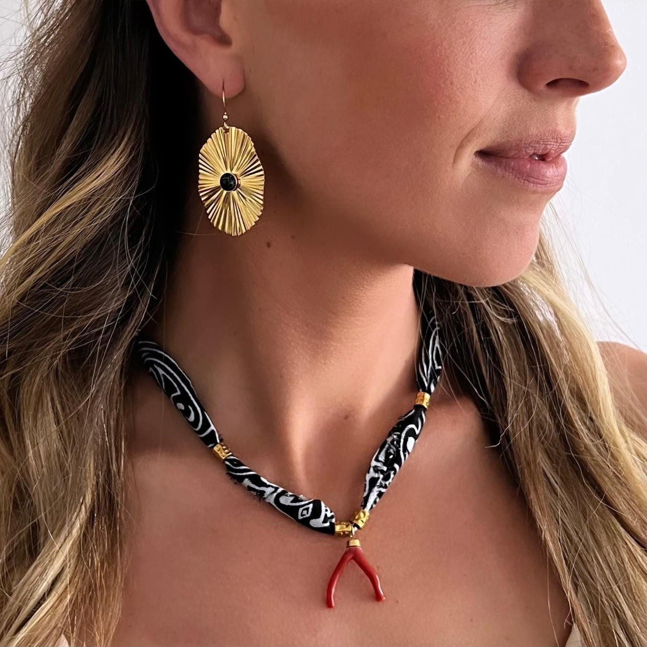 Collier Bandana noir avec son pendentif branche de Corail rouge de Méditerranée. A la fois tendance et moderne, ce bijou apporte du style à votre look. Le Corail protège, porte bonheur et éloigne le mauvais œil.Dimensions :Réglable grâce à la chainette d'extension de 36cm à 42cm.