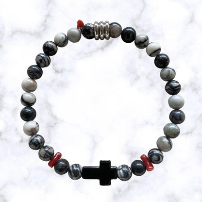 Bracelet élastique en perles d'Aventurine grise. Au centre une croix noire en acier inoxydable entourée de petits morceaux de corail rouge de Méditerranée.L'Aventurine stimule l'empathie et la compréhension de l'autre, elle permet également de booster les capacités intuitives.Le Corail protège, porte bonheur et éloigne le mauvais œil.
3 Tailles.