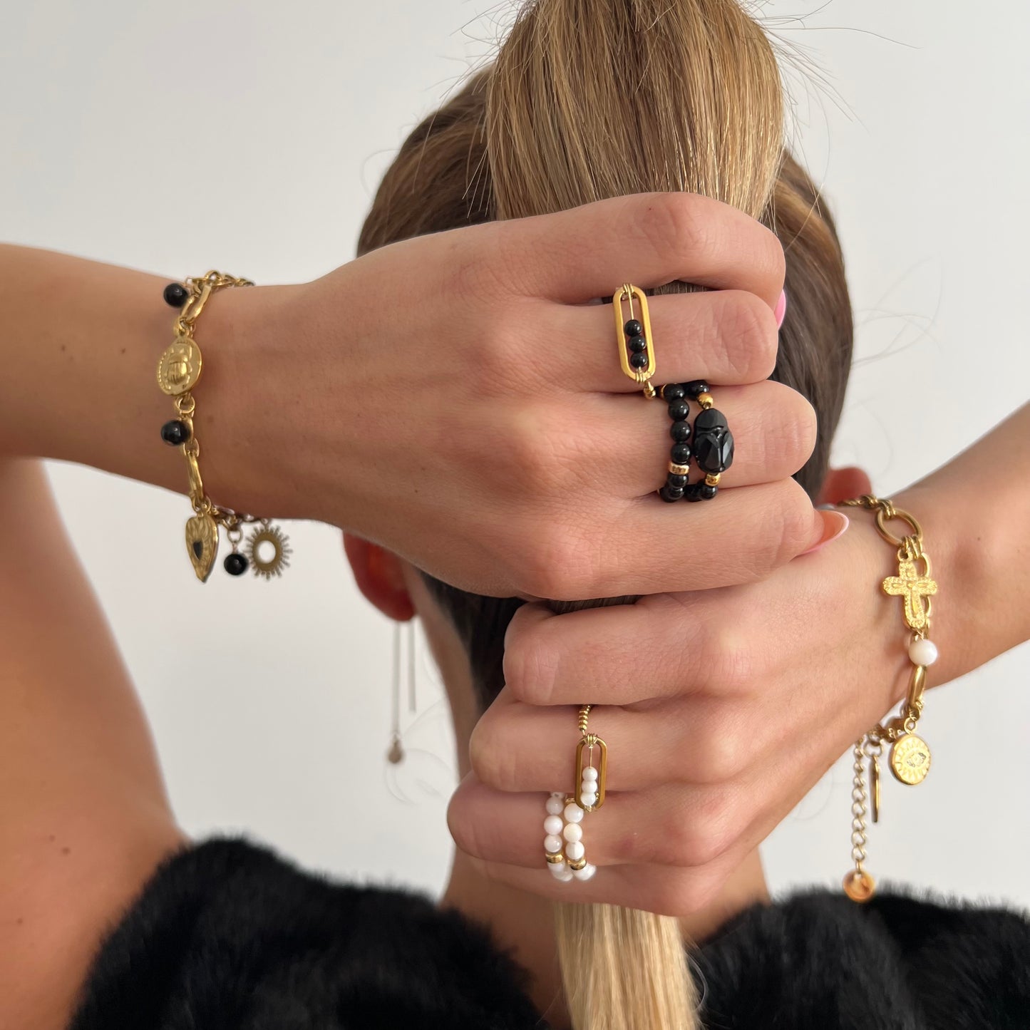 Bagues femme Déa portées en accumulation avec perles de Nacre blanche et Onyx noir, accompagnées de bracelets dorés, création artisanale corse