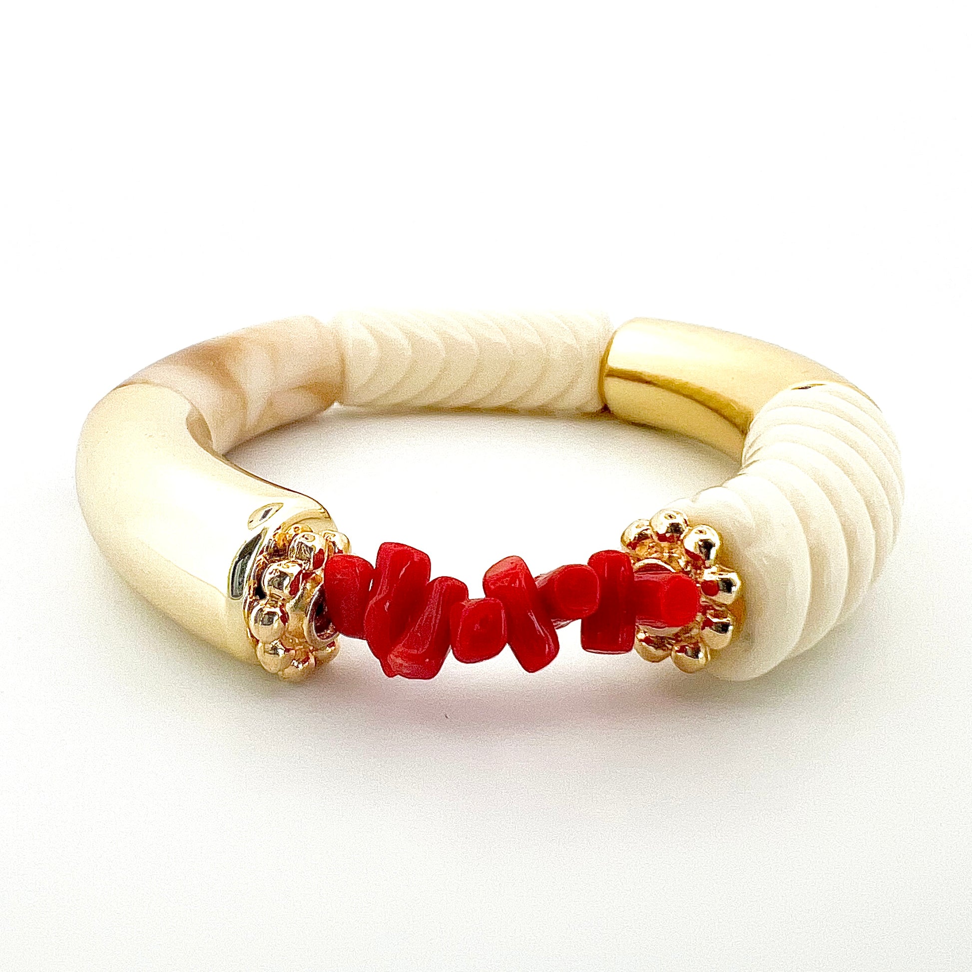 Le bracelet Goa blanc torsadé, fait main, associe l’élégance de l’acrylique a finesse des rondelles dorées à l’or fin et la symbolique du Corail rouge de Méditerranée, connu pour ses vertus protectrices et porte-bonheur