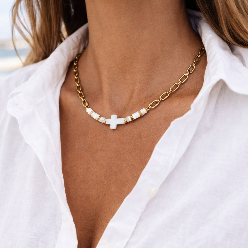 Collier femme Saveria porté avec croix en nacre blanche, perles blanches et chaîne en acier inoxydable doré